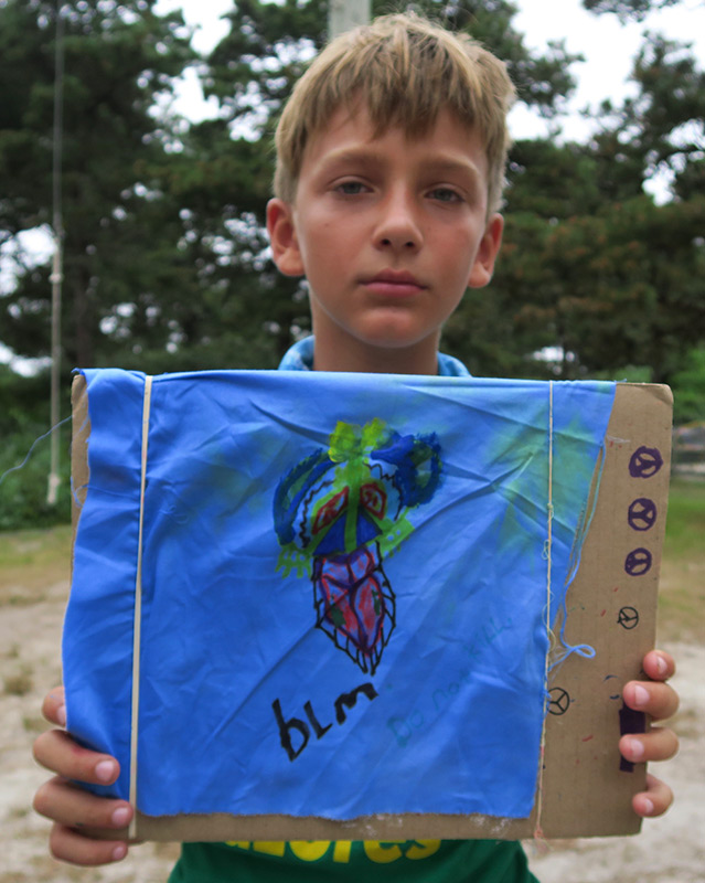 A child holding a hand-painted wish flag